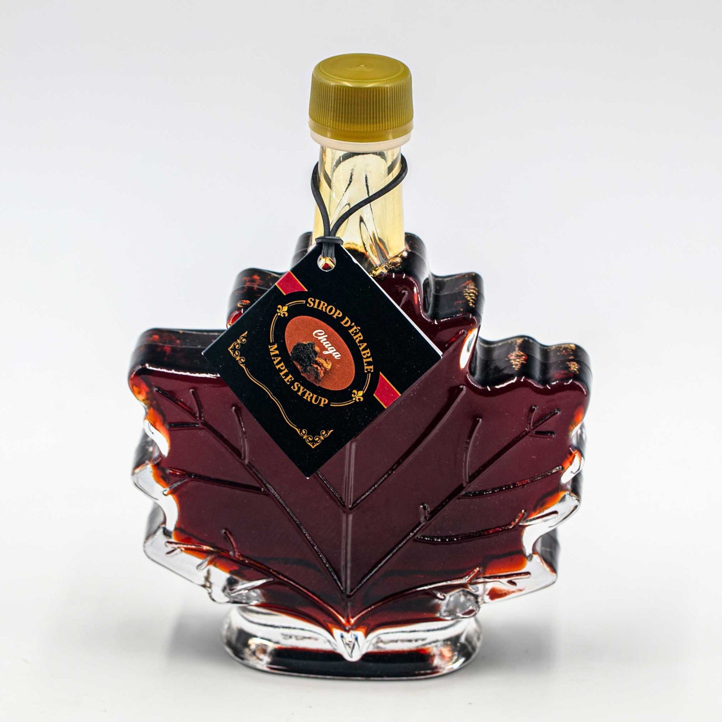 Infused maple syrup chaga Nature Artisan 100ml in a maple leaf glass bottle.