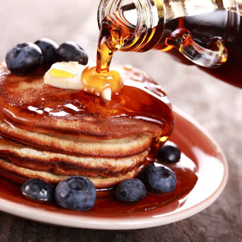 Nature Artisan Syrup poured on a pile of pancakes